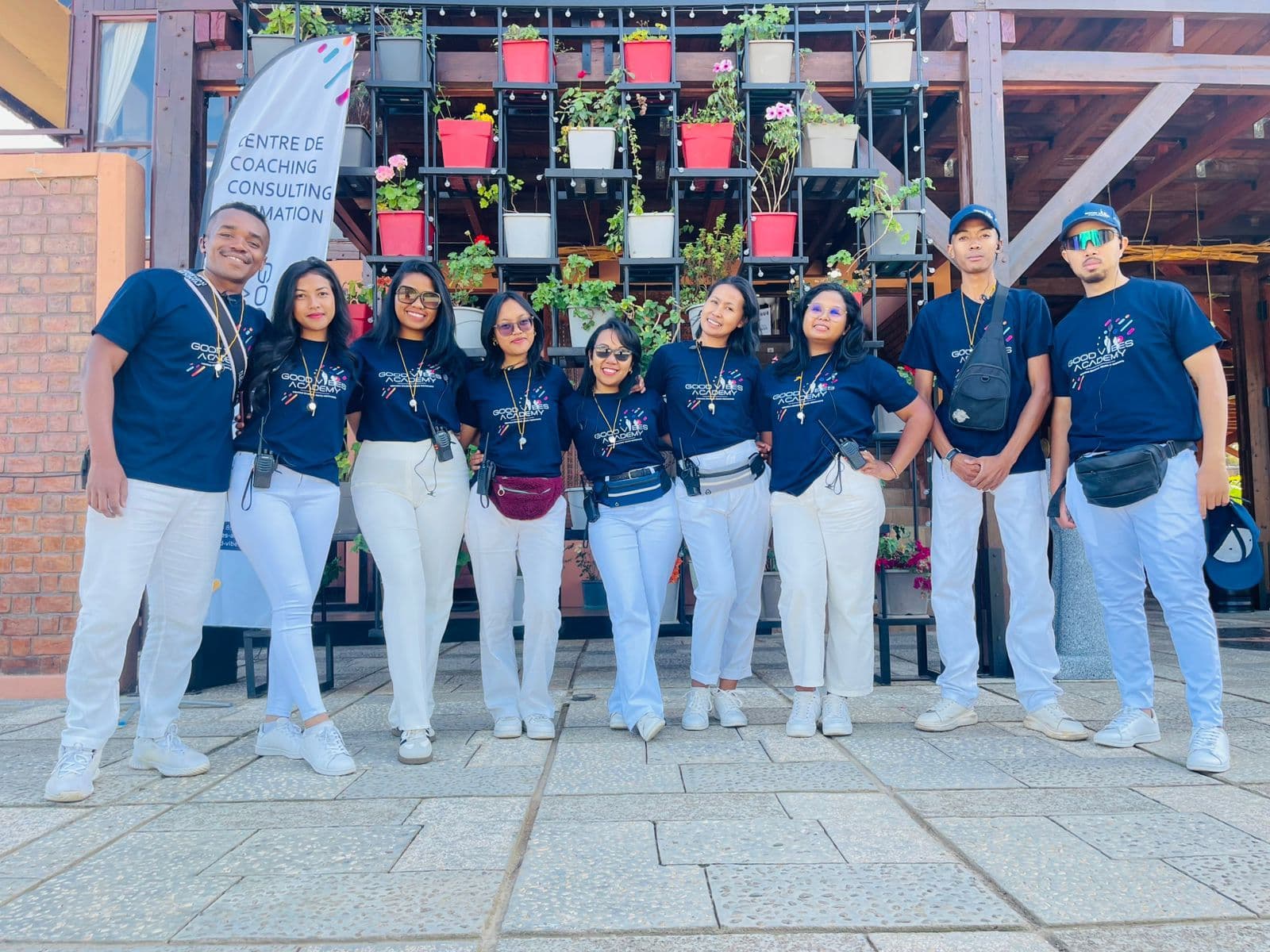 L'équipe GVA en tee-shirts bleu marine et pantalons blancs devant la bannière « Centre de coaching, consulting, formation »