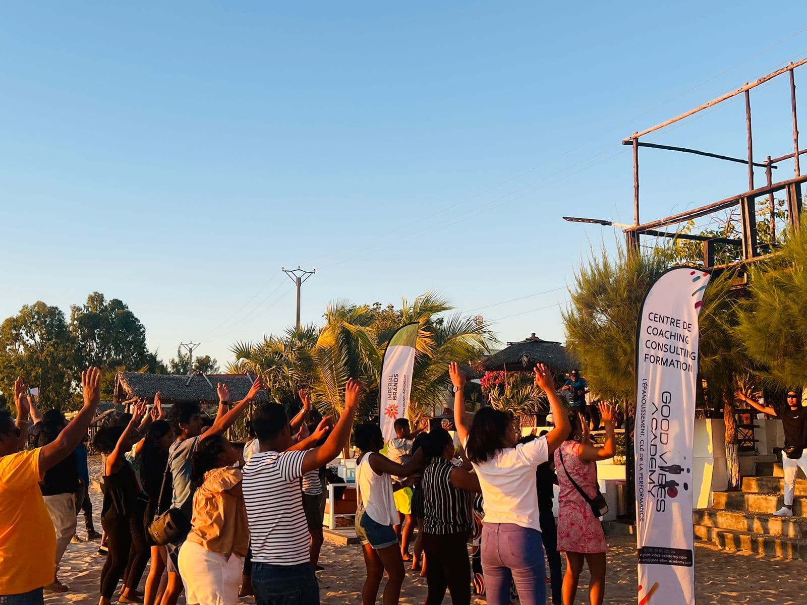 Participants bras levés pendant une activité de team building en extérieur, en fin de journée